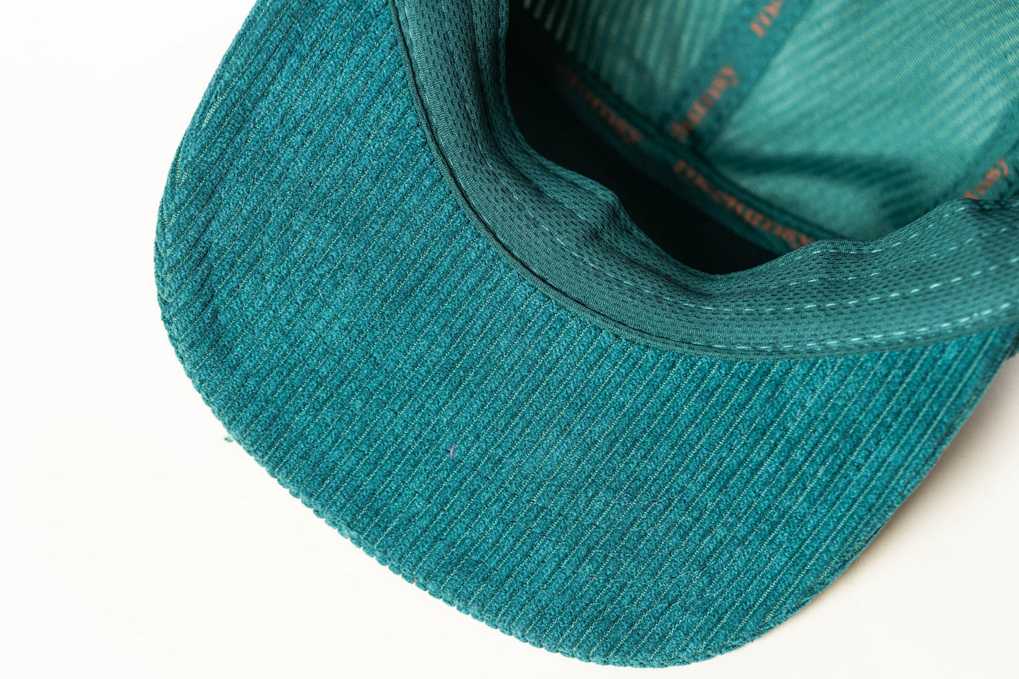 View of the underside of the bill of the McClumsy 5 Panel Rich Green Corduroy Hat