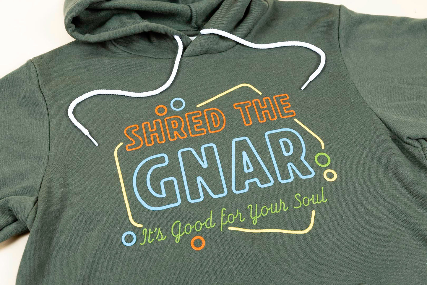 Shred The GNAR Hoodie Green Logo Closeup Front
