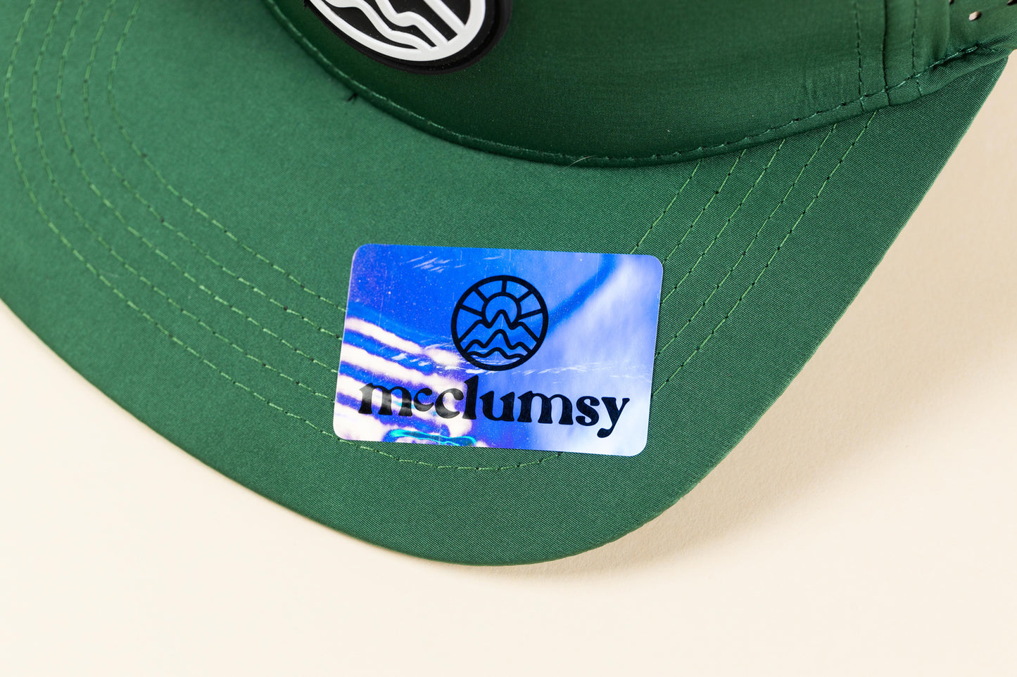 McClumsy sticker on the bill of the 7 panel McClumsy Trucker Hat